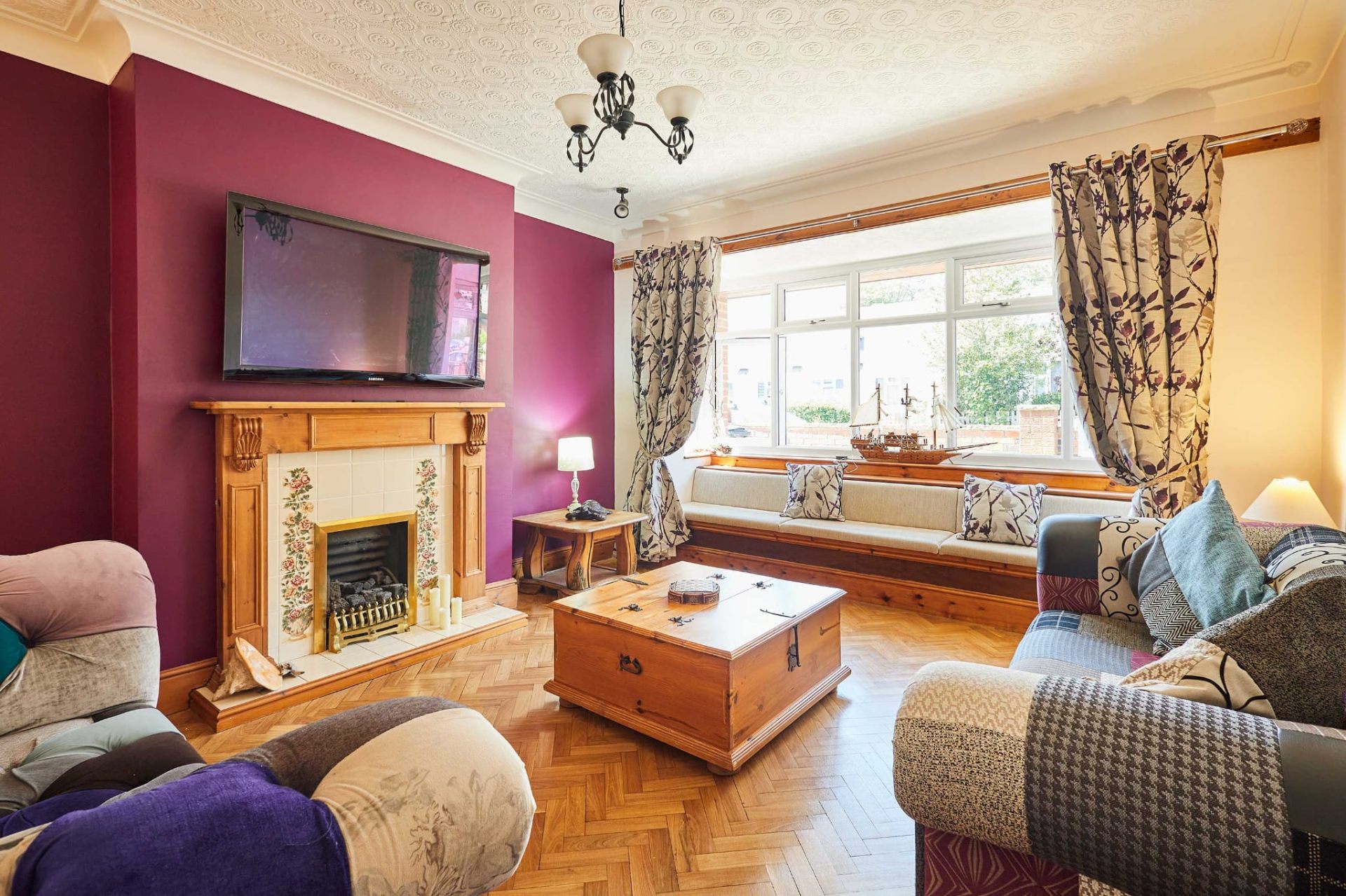Spacious lounge at Sea Breeze Skegness with bay window seat, fireplace and patchwork sofas