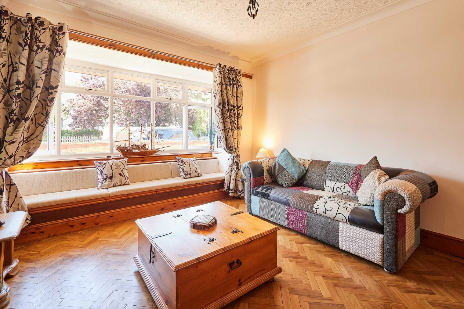 Bright bay window seat and patchwork sofa in the Skegness holiday let lounge