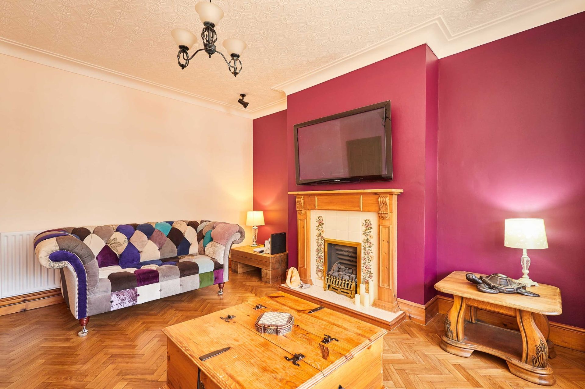 Second sitting room with feature fireplace and parquet floor, perfect for cosy evenings
