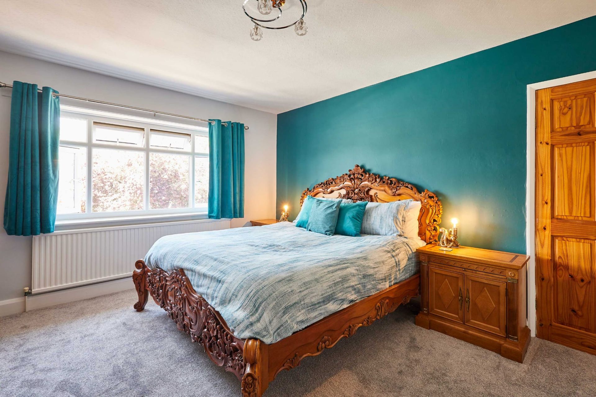 Additional double bedroom with teal accents and traditional carved bed