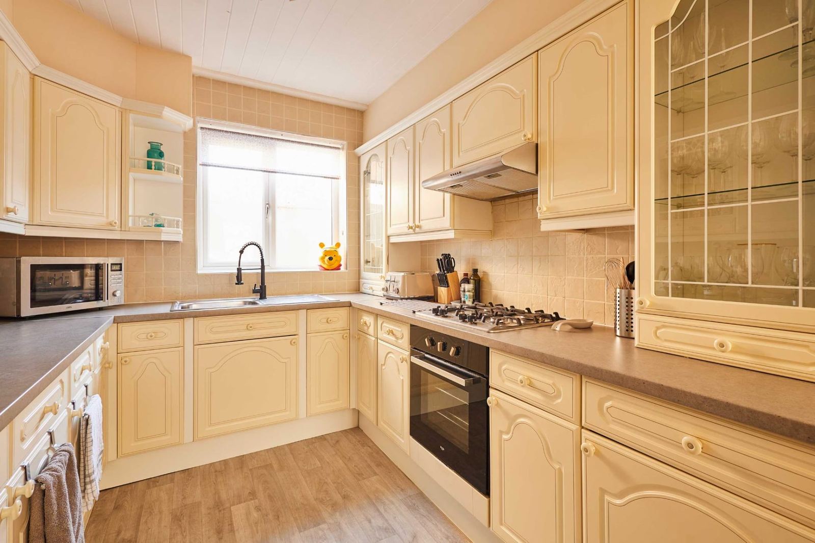 Fully fitted cream kitchen with gas hob, oven and everything for self-catering