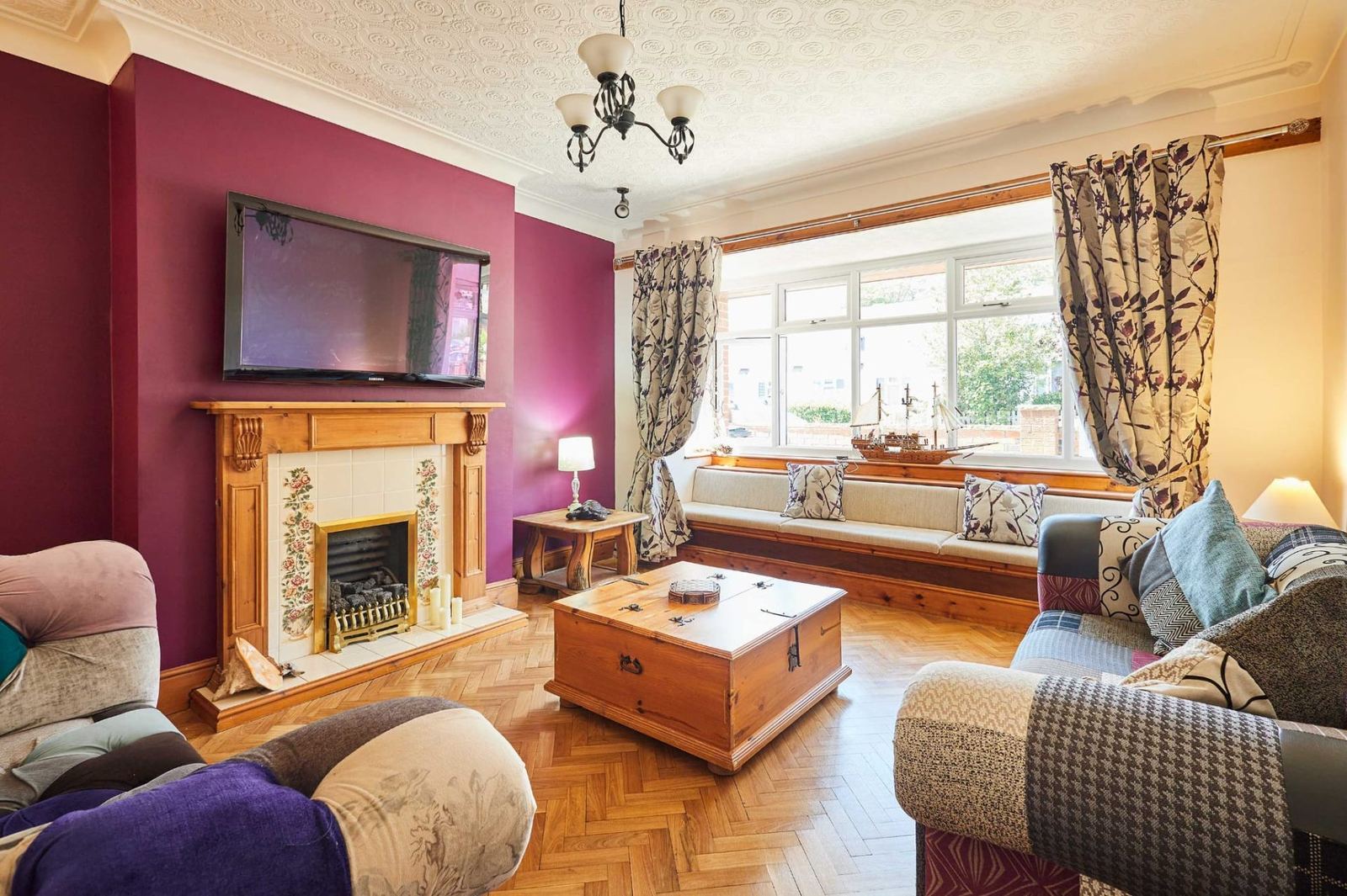 Spacious lounge at Sea Breeze Skegness with bay window seat, fireplace and patchwork sofas